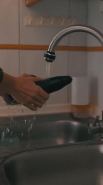 Ev aşçısı taze ürünleri yıkıyor, patlıcan, kabak ve dolma biber de dahil, akan suyun altında.