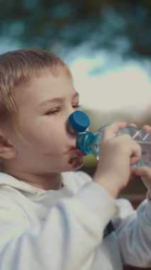 Genç çocuk dışarıda atıştırmalık ve ferahlatıcı bir şeyler içiyor.