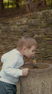 Anne ve oğlu bir taş çeşmenin üzerine eğilmiş, parkta tatlı su içiyorlardı.