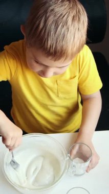 Çocuk kaseden yoğurt tadıyor.