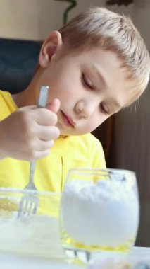 Çocuk dikkatli bir şekilde çatalla karıştığında malzemeleri bir kaseye doldurur.