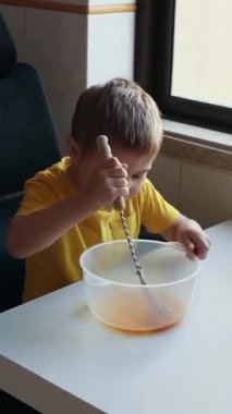 Konsantre çocuk malzemeleri bir kasede çırpıyor, bir tarif hazırlıyor.