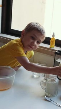 Elma suyuna elma püresi hazırlarken süt ekleyen bir çocuk