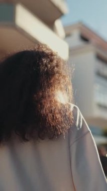 Romantik çift, güneşli bir günde el ele tutuşup sokakta yürüyor.