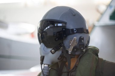 Pilot uçuş giysisi ve oksijen maskesi ve koyu renk güneşlik takıyor.