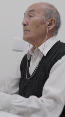 İşitme cihazı takan kıdemli adam biraz krakerden hoşlanıyor.