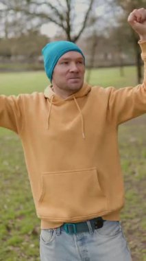 Parkta yalnız dans eden mutlu adam.