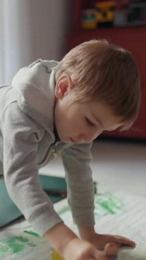 Çocuk, korunaklı bir zeminde yaratıcılığı keşfetmek için resme dalmış.