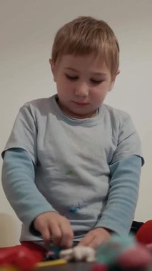 Yaratıcı oyun oynayan, renkli modelleme kilini şekillendiren bir çocuk