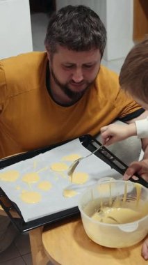 Baba, küçük oğluna kurabiye pişirmeyi öğretiyor. Yürek ısıtan bir aile anı yaratıyor.