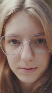 Parkta poz veren sarışın genç bir kadının portresi.