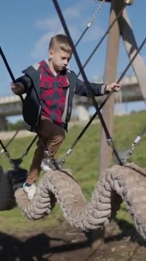 Çocuk dikkatli bir şekilde salıncakta sallanıyor, denge ve koordinasyonu geliştiriyor.