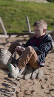 Çocuk oyun parkında el şeklinde bir yay binicisinin üstünde zıplayarak eğleniyor.