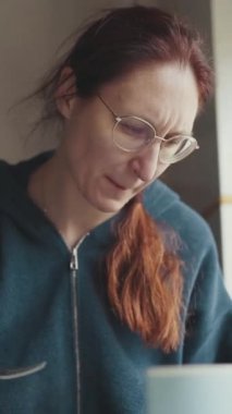 Kadın mutfağında kahvaltı yapıyor, akvaryumun yanında.