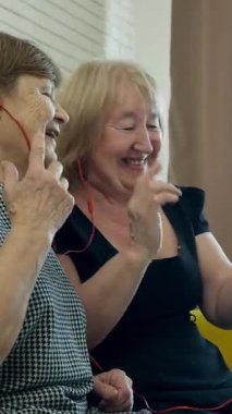 Bej desenli kumaş üzerine dikiş makinesi kullanan bir terziyi kapat.