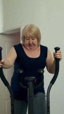 Üst düzey bir kadın sarı bir koltukta otururken telefonla konuşuyor.