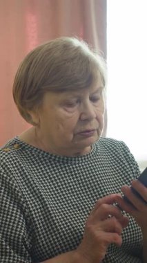 Üst düzey kadın evde akıllı telefondan arıyor ve konuşuyor.