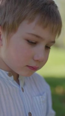 Güneşli bir günde lolipopun tadını çıkaran bir çocuk.