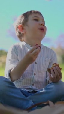 Anne ve oğlu güzel bir anı paylaşıyorlar, parkta birlikte atıştırmalık yiyorlar.