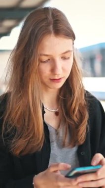 Ergen, ulaşımı bekliyor, sosyal medyayı araştırıyor.