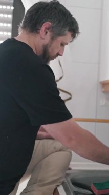 Parlak bir mutfakta bulaşık yıkayan bir adam.