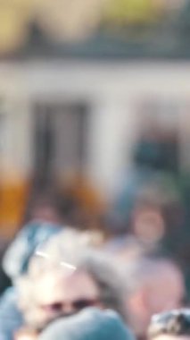 Şehir caddesinde yürüyen bulanık kalabalığın üzerinde sabun köpükleri yüzüyor.