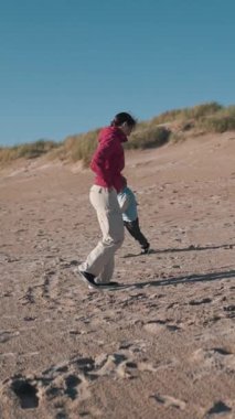 Anne ve oğlu güzel kumlu bir plajda birlikte güzel vakit geçiriyorlar.