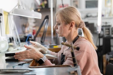 Kadınların elleri kuyumcuda malzeme şekillendiriyor, yeni bir tasarım üzerinde çalışıyor.