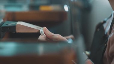 Mücevher tezgahında el yapımı gümüş bir yüzüğü dosyalayan bir kuyumcunun elleri.