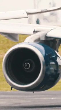 Beyaz ve mavi yolcu uçağı bir havaalanı pistinde taksicilik yapıyor.