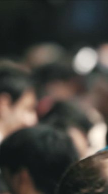 Bir tapınakta mavi sarıklı bir adamla dua eden kalabalık.