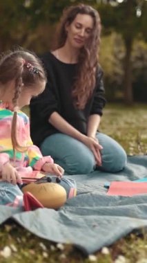 Kadın ve kız parkta yaratıcı bir aktivitenin keyfini çıkarıyorlar.