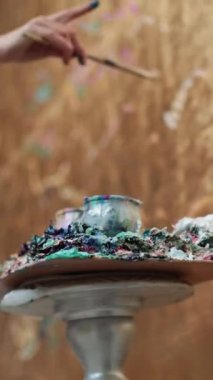 Kadın sanatçı fırçayla altın duvarı boyuyor