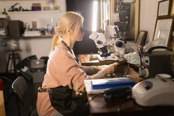 Sanatçı kadın özel mikroskop ile titizlikle araştırıyor, hassasiyet ve kalite sağlıyor.