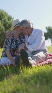 Yaşlı bir çift piknik sırasında hassas bir anı paylaşıyor. Emeklilikte sevgi ve arkadaşlık gösteriyorlar.