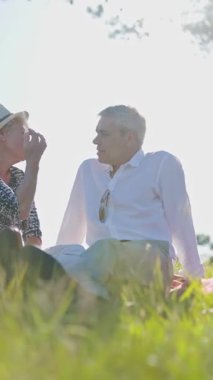 Kıdemli çift güneşli bir parkta piknik yaparken keyifli bir sohbet yapıyorlar.