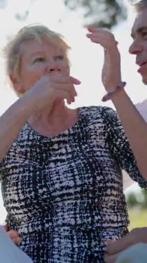 Mutlu yaşlı çift güneşli bir parkta romantik bir piknik yapıyor.