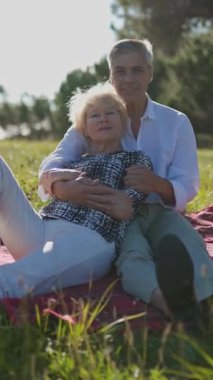 Mutlu emekli çift güneşli bir parkta piknik yapıyor.