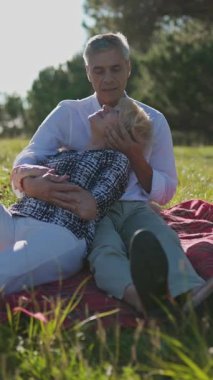 Yaşlı çift dinlenme gününün tadını çıkarıyor, parkta battaniyeye sarılıyorlar.