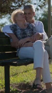 Sevecen, emekli bir çift parktaki bankta huzurlu bir anın tadını çıkarıyor.