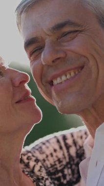 Mutlu yaşlı çift açık havada hassas bir anı paylaşıyor.