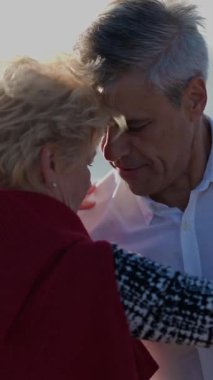 Romantik olgun çift sahilde tango basamaklarının keyfini çıkarıyor.