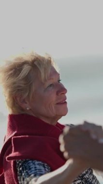 Yaşlı çift deniz kenarında romantik bir dans ediyor.