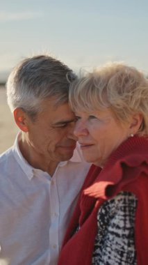 Yaşlı çift sahilde romantik bir anın tadını çıkarıyor.