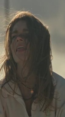 Enerjik kadın, bulutlu ve rüzgarlı bir günde çatıda atlama ipiyle egzersiz yapmaktan hoşlanır.