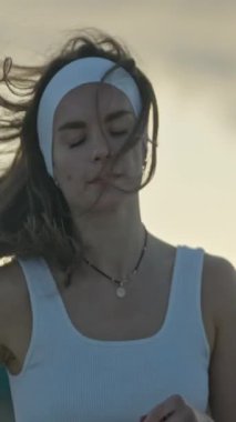 Zarif kadın tai chi yapıyor, hafif bir esintinin ortasında sükuneti kucaklıyor.