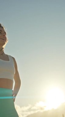 Batan güneşin altında poz veren genç atletik kadın