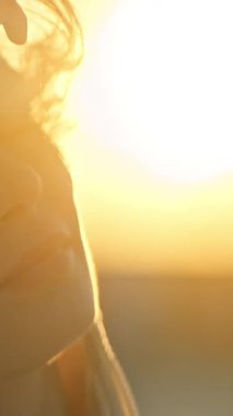 Güzel genç bayan, altın saat güneş ışığının tadını çıkarıyor