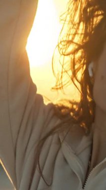 Kulaklık takan genç ve güzel bir kadın altın saat gün batımının tadını çıkarıyor.