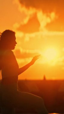 Gün batımında dans eden bir kadın, güzel bir siluet.